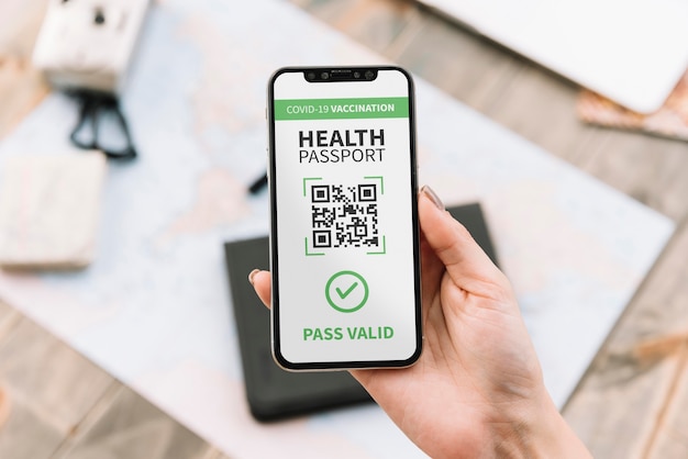 Draufsicht einer Person, die einen virtuellen Gesundheitspass auf dem Smartphone hält