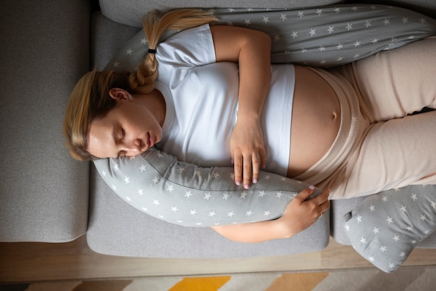 Draufsicht einer schwangeren Frau, die ein Stillkissen verwendet