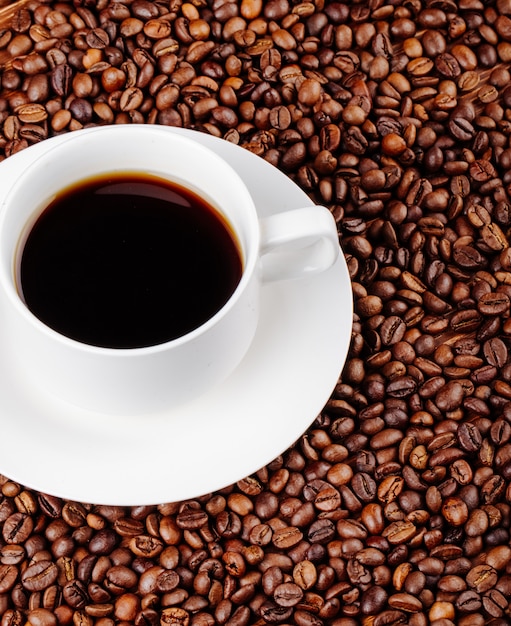 Draufsicht einer Tasse Kaffee auf Kaffeebohnen