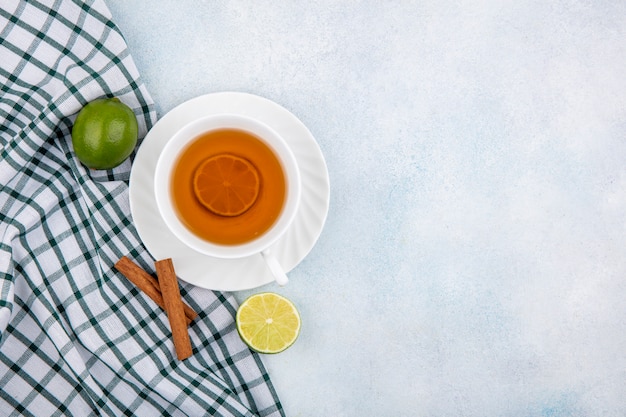 Kostenloses Foto draufsicht einer tasse schwarzen tees auf karierter tischdecke auf weiß mit kopienraum