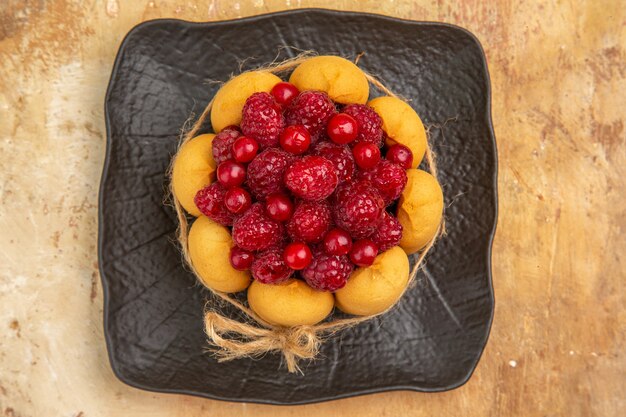 Draufsicht eines Geschenkkuchens mit Früchten auf gemischtem Farbhintergrund