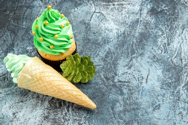 Draufsicht Eiscreme Weihnachtsbaum Cupcake goldene Weihnachtsverzierung auf grauem Hintergrund