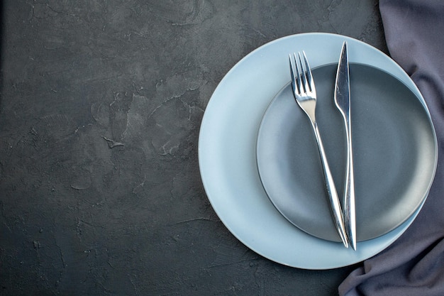 Draufsicht elegante Teller mit Gabel und Messer auf dunklem Hintergrund Besteck Weiblichkeit Diner Hunger bunt