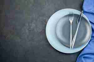 Kostenloses Foto draufsicht elegante teller mit gabel und messer auf dunklem hintergrund zieren hunger diner besteck bunt