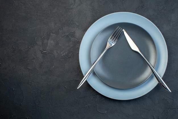 Kostenloses Foto draufsicht elegante teller mit messer und gabel auf dunklem hintergrund hunger besteck weiblichkeit buntes diner