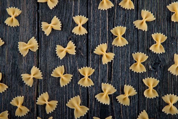 Kostenloses Foto draufsicht farfalle nudeln auf schwarzem hölzernem hintergrund