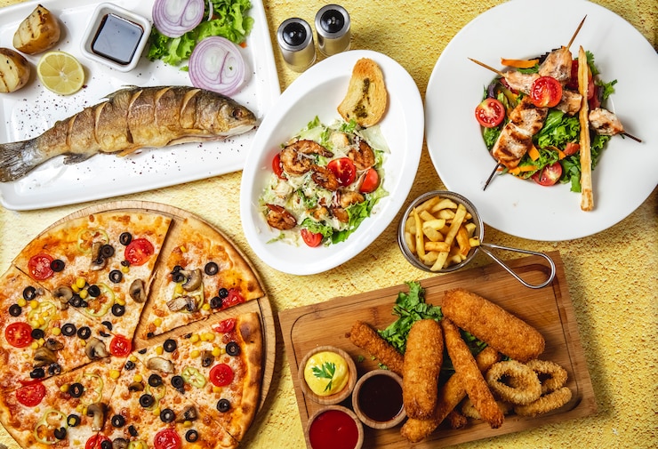 Kostenlose Foto draufsicht fast-food-mix caesar shrimps salat hühnchen spieß salat pilz pizza mozzarella sticks zwiebelringe gegrillter fisch rote zwiebel granatapfelsauce salz pfeffer an