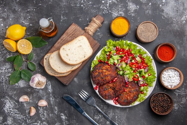 Draufsicht Fleischkoteletts mit Salat und Brot
