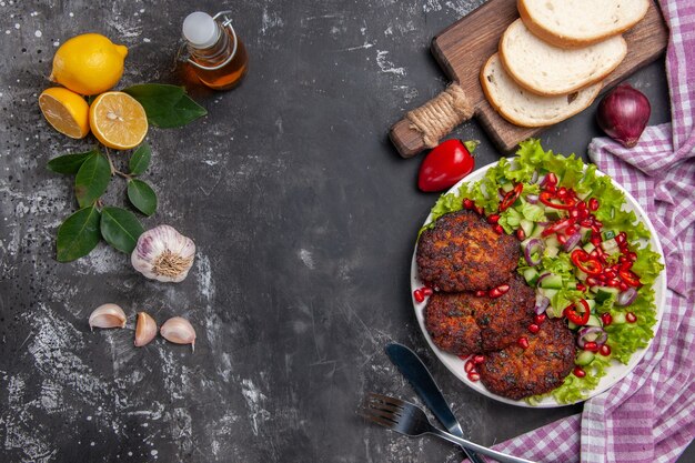 Draufsicht Fleischkoteletts mit Salat und Brot