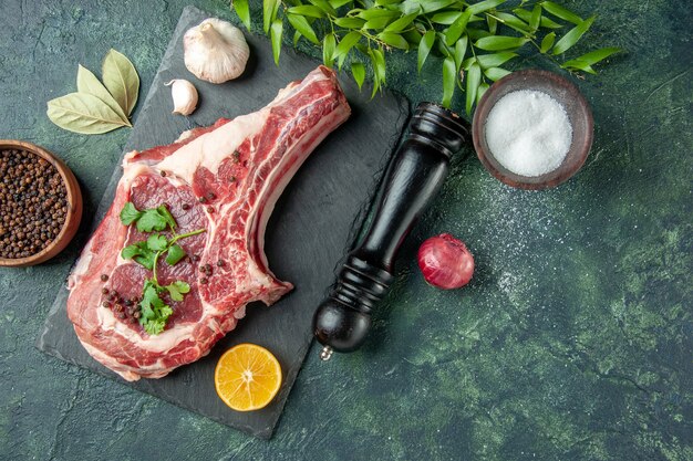 Draufsicht Fleischscheibe mit Pfeffer und Salz auf dunkelblauem Hintergrund Farbe Lebensmittel Fleisch Küche Tier Huhn Kuh Metzger