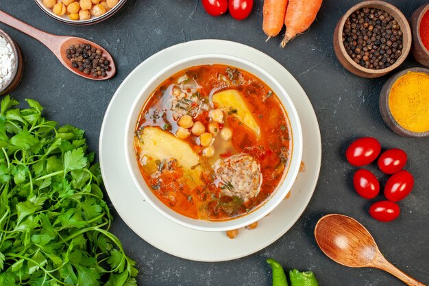 Draufsicht Fleischsuppe mit Gemüse und Gewürzen auf dunklem Hintergrund