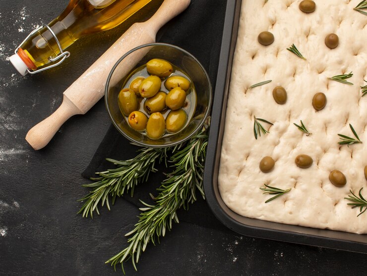 Kostenlose Foto draufsicht focaccia teig mit oliven