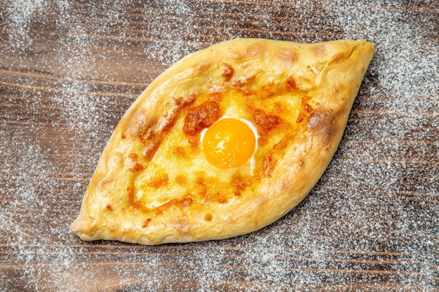 Draufsicht frisch gebackenes Brot mit gekochtem Ei auf braunem Schreibtisch Teig Essen backen Brötchen Mahlzeit Ei