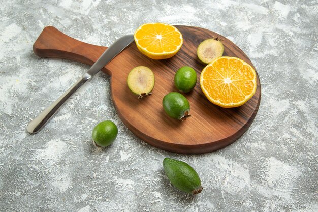 Draufsicht frisch geschnittene Orangen mit Feijoa auf weißer Oberfläche reife Frucht exotisch frisch