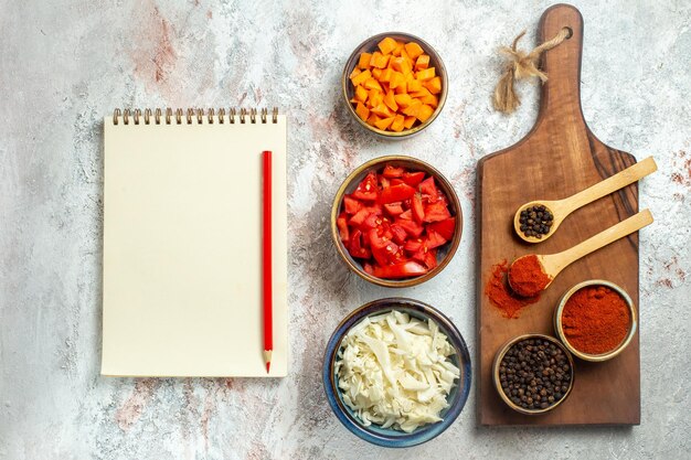 Draufsicht frisch geschnittener Kohl mit Tomaten und Pfeffer auf weißem Raum