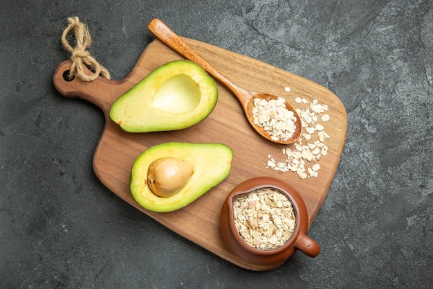 Draufsicht frische Avocado mit rohem Getreide auf einer grauen Oberfläche Frucht exotisches Frühstück frisch