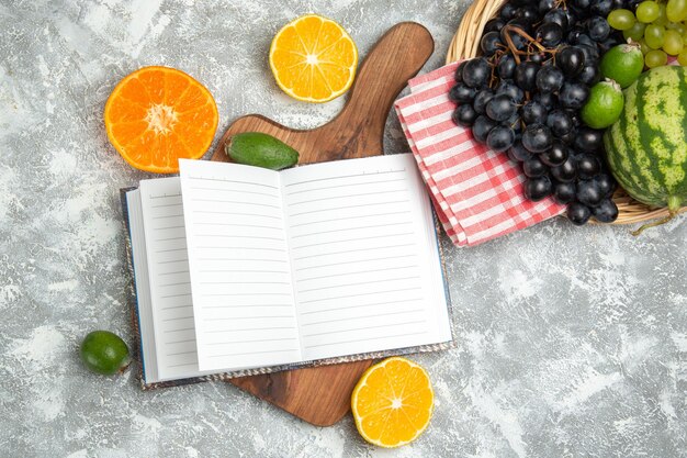 Draufsicht frische dunkle trauben mit orangen und wassermelone auf weißer oberfläche reife frucht milder baum frische vitamine