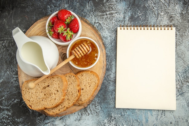 Draufsicht frische Erdbeeren mit Brot und Honig auf der dunklen Oberfläche Frucht süßes Gelee