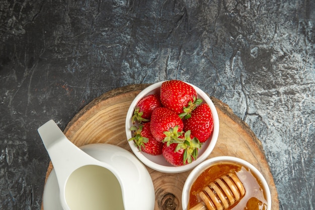 Draufsicht frische Erdbeeren mit Honig und Brot auf dunkler Oberfläche Lebensmittelfrucht süßes Gelee