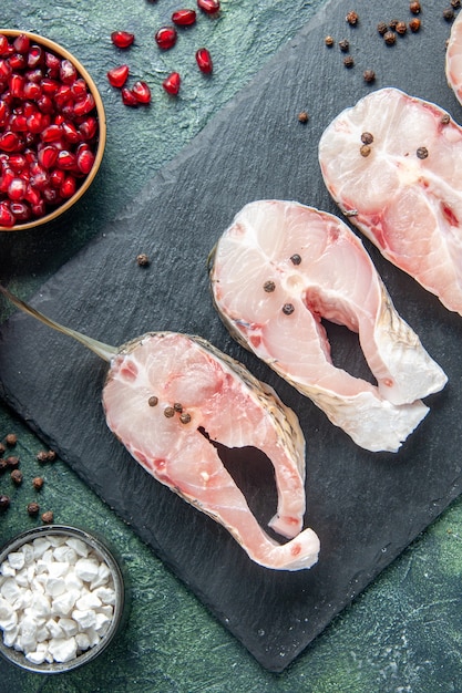 Draufsicht frische Fischscheiben auf dunklem Tischfleisch Meeresfrüchte Meeresfrüchte Rohwasser Lebensmittel Ozean Pfeffer