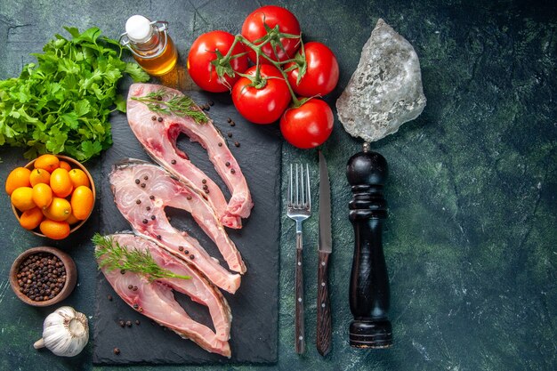 Draufsicht frische Fischscheiben mit Kumquats auf dunkelblauem Hintergrund