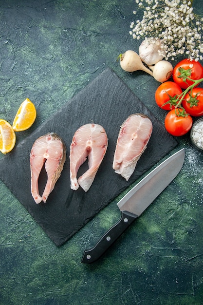 Draufsicht frische Fischscheiben mit roten Tomaten auf der dunklen Oberfläche Meeresfrüchte Meeresfleisch Meeresmehl Wasser Pfeffer Pfeffer Gericht Lebensmittelsalat