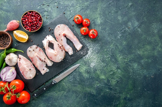 Draufsicht frische Fischscheiben mit roten Tomaten auf dunkelblauem Hintergrund Ozeanfleisch Meeresfrüchte Pfeffergericht Meeresmehl Wasser Lebensmittel freier Raum