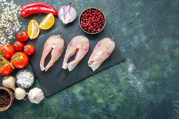 Draufsicht frische Fischscheiben mit roten Tomaten auf dunklem Hintergrund Meeresfrüchte Meeresfleisch Meeresmehl Gericht Essen Salat Salat Pfeffer