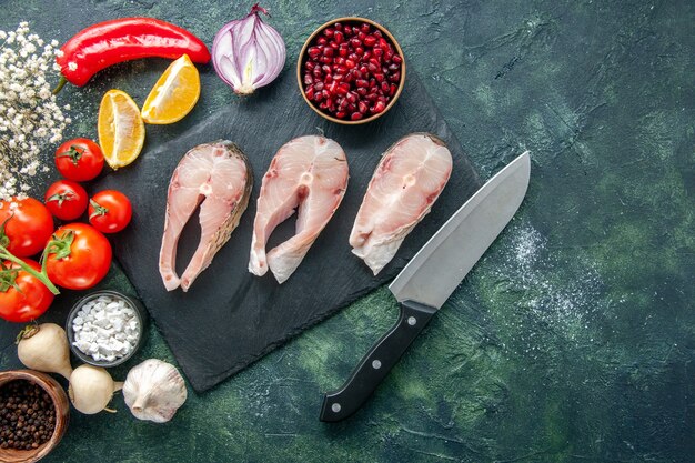 Draufsicht frische Fischscheiben mit roten Tomaten auf dunklem Hintergrund Meeresfrüchte Ozean Meeresfrüchte Gericht Essen Salat Wasser Pfeffer