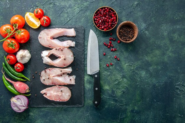 Draufsicht frische Fischscheiben mit roten Tomaten auf dunklem Hintergrund Ozeanfleisch Meeresmehl Wasser Essen Pfeffer Gericht Meeresfrüchte