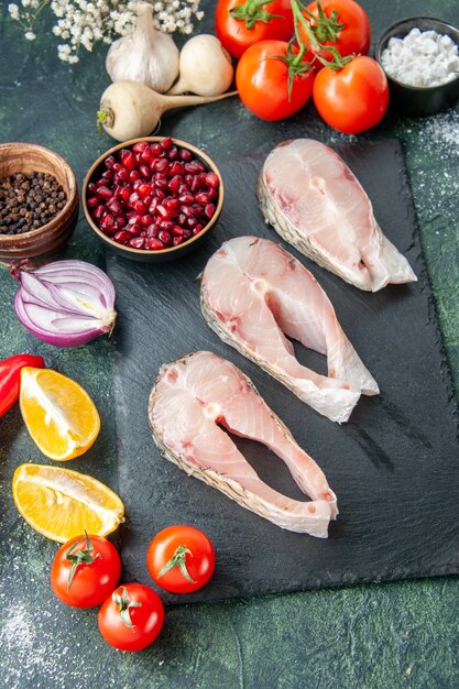 Draufsicht frische Fischscheiben mit roten Tomaten auf dunklem Tisch Meeresfrüchte Meeresfleisch Meeresmehl Pfeffer Gericht Gerichtssalat Wasser