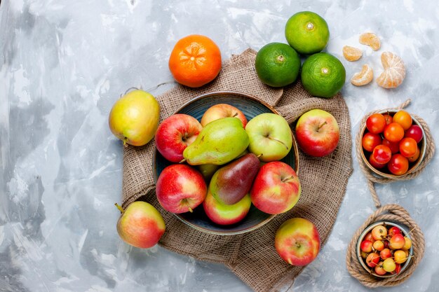 Draufsicht frische Früchte Äpfel Mandarinen und Mango auf hellweißem Schreibtisch