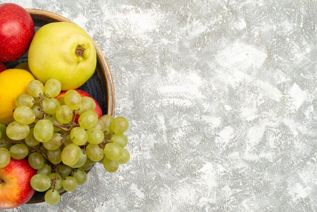 Draufsicht frische Früchte Zusammensetzung Äpfel Trauben und andere Früchte auf weißem Hintergrund frische milde Frucht reife Farbe