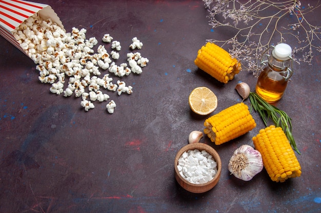 Kostenloses Foto draufsicht frische gelbe hühneraugen mit popcorn auf dunklem schreibtisch mais-snack-essen roh frisch