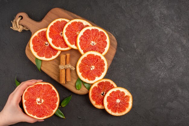 Draufsicht frische Grapefruitscheiben auf dunklem Hintergrund