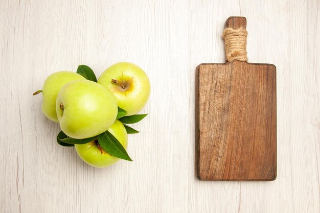 Draufsicht frische grüne Äpfel ausgereifte und reife Früchte auf weißem Schreibtisch Pflanzenfrüchte färben frischen grünen Baum