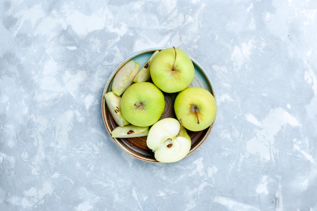 Draufsicht frische grüne Äpfel in Scheiben geschnitten und ganze Früchte auf der hellen Oberfläche