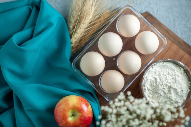 Draufsicht frische Hühnereier auf leichtem Tischtee-Nachtischkuchen-Zuckerfruchtkekskeks-süßem Kuchenteig