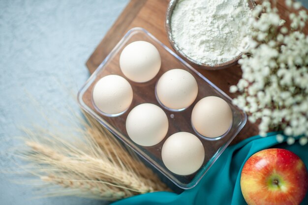 Draufsicht frische Hühnereier auf leichtem Tischtee-Nachtischkuchen-Zuckerfruchtkekskeks-süßem Kuchenteig