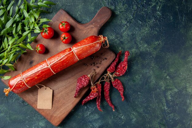 Draufsicht frische leckere Wurst mit Tomaten auf dunklem Hintergrund Tier Sandwich Mahlzeit Brot Brötchen Burger Lebensmittelfarbe Fleisch