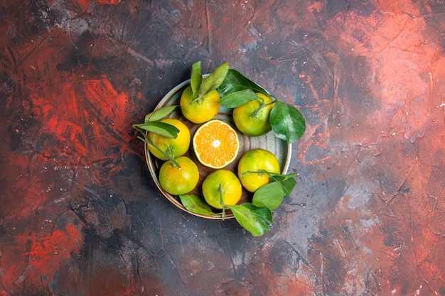 Kostenloses Foto draufsicht frische mandarinen auf dunkelroter oberfläche mit freiem raum
