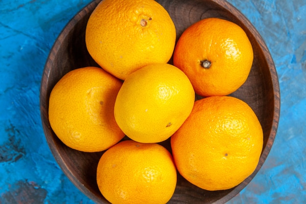 Kostenloses Foto draufsicht frische mandarinen im teller auf blauem hintergrund