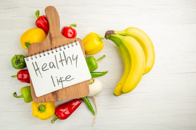 Draufsicht frische Paprika mit Bananen auf weißem Hintergrund Diätsalat gesundes Leben reife Farbe