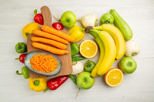 Draufsicht frische Paprika mit Bananen, Karotten und Äpfeln auf weißem Hintergrund Fotosalat gesundes Leben reife Farbdiät