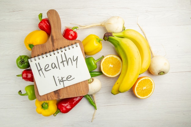 Draufsicht frische Paprika mit Bananen und Orange auf weißem Hintergrund Diätsalat gesundes Leben Foto reife Farbe