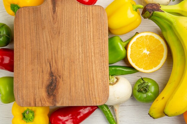 Draufsicht frische Paprika mit Bananen und Orange auf weißem Hintergrund Salat gesundes Leben Foto Farbdiät