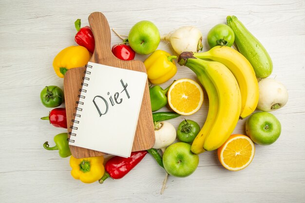 Draufsicht frische Paprika mit Bananen und Orange auf weißem Hintergrund Salat gesundes Leben Foto reife Farbe