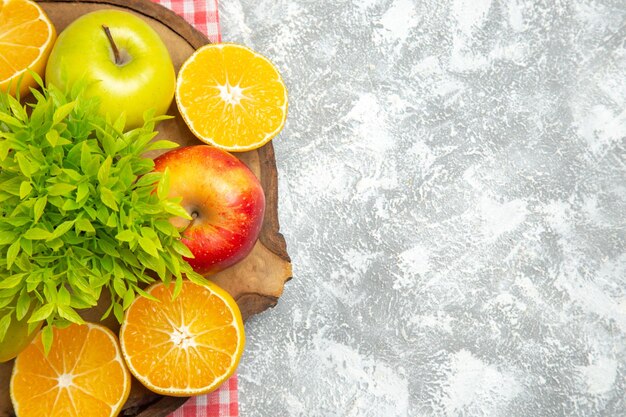 Draufsicht frische Äpfel mit geschnittenen Orangen auf weißem Hintergrund reife reife Apfelfrucht frisch