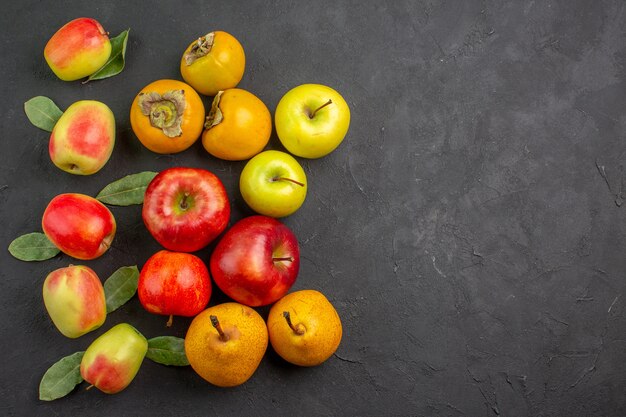 Draufsicht frische Äpfel mit Kaki und Birnen auf dunklem Tisch ausgereifter Baum frisch reif