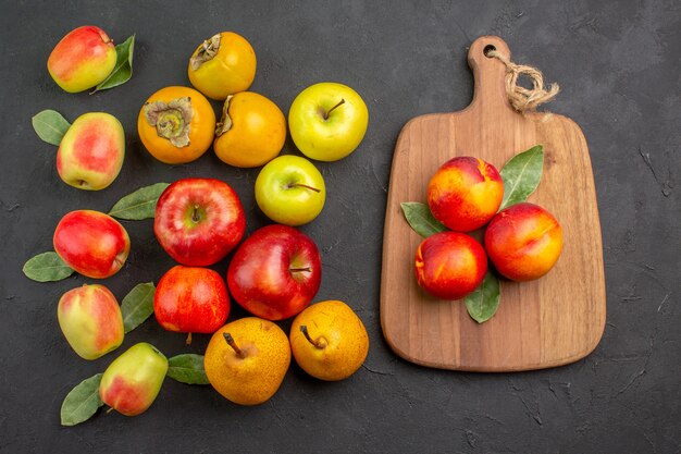 Draufsicht frische Äpfel mit Kakis und Birnen auf dunklem Schreibtisch ausgereifter Baum frisch reif